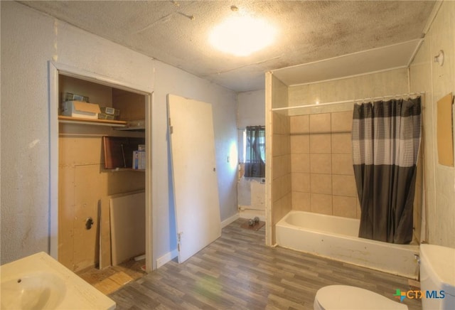 bathroom featuring shower / tub combo, a textured ceiling, toilet, and hardwood / wood-style floors