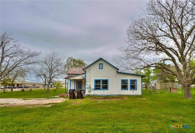 rear view of house featuring a lawn