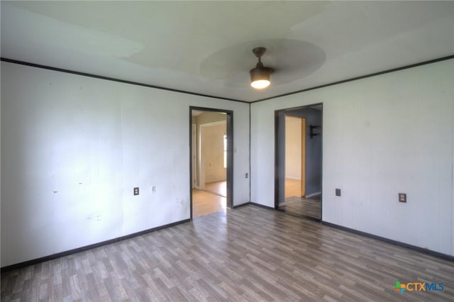 spare room with hardwood / wood-style flooring, ceiling fan, and ornamental molding