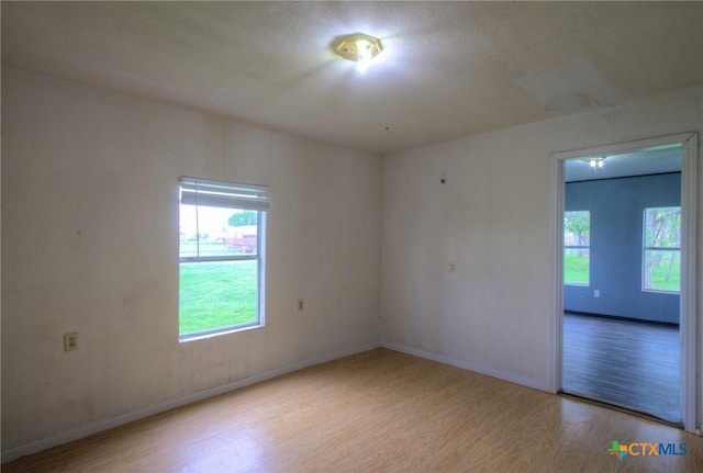 unfurnished room featuring a textured ceiling and light hardwood / wood-style floors