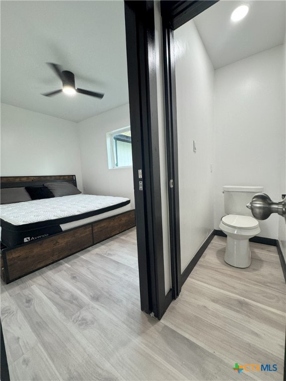 bathroom with toilet, wood finished floors, baseboards, and a ceiling fan