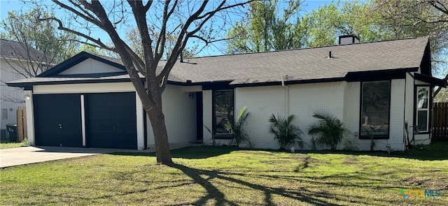 ranch-style house with a shingled roof, driveway, a front yard, a garage, and a chimney