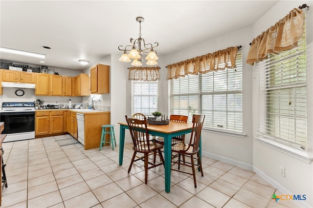 dining space with light tile patterned flooring, baseboards, and an inviting chandelier