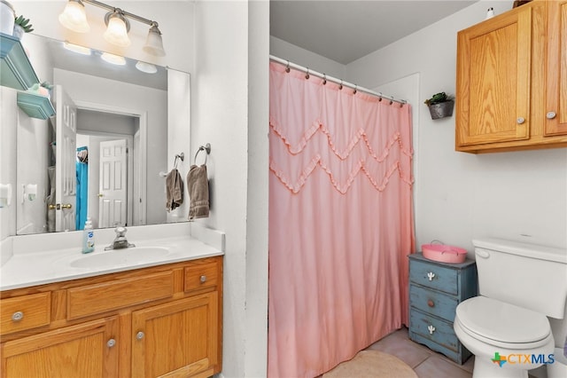 bathroom with curtained shower, vanity, tile patterned flooring, and toilet