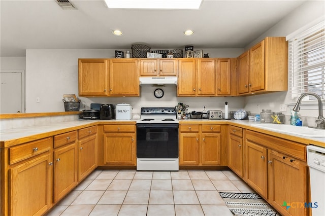 kitchen featuring under cabinet range hood, electric stove, visible vents, a sink, and a peninsula
