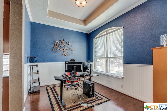 office featuring ornamental molding, hardwood / wood-style flooring, and a tray ceiling