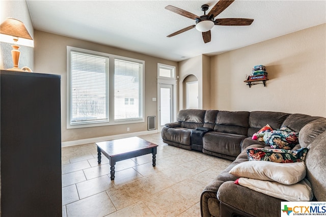 living room with light tile patterned flooring, a textured ceiling, and ceiling fan