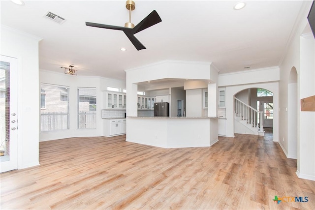 unfurnished living room with ornamental molding, ceiling fan, and light hardwood / wood-style flooring