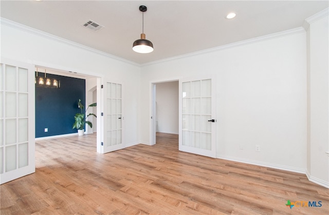 spare room with ornamental molding, french doors, and light wood-type flooring