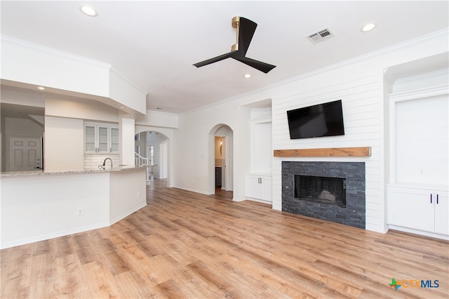 unfurnished living room with ceiling fan, light hardwood / wood-style flooring, and ornamental molding