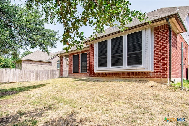 rear view of property with a lawn