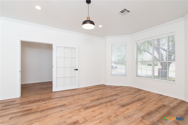 unfurnished room featuring ornamental molding and light wood-type flooring