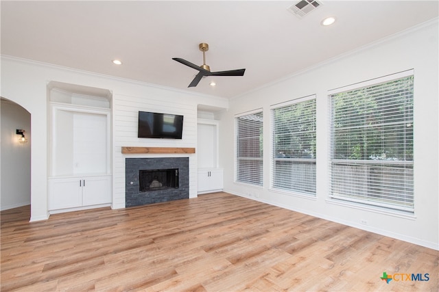 unfurnished living room with a fireplace, ornamental molding, ceiling fan, and light hardwood / wood-style flooring