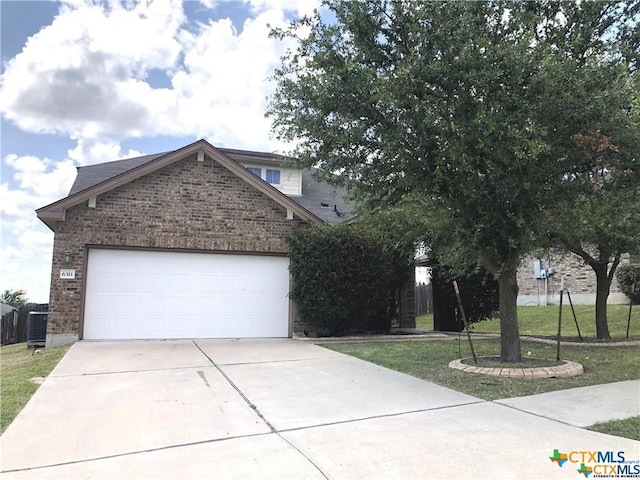 view of front facade with an attached garage, a front lawn, concrete driveway, and brick siding