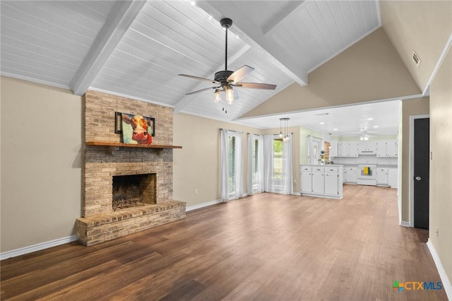 313 Pheasant Dr, Victoria, TX 77905 - unfurnished living room featuring ceiling fan, light wood finished floors, a fireplace, beamed ceiling, and baseboards