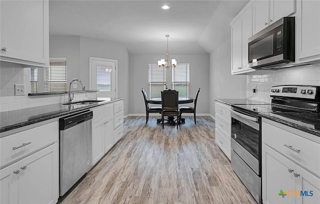 kitchen with white cabinetry, stainless steel appliances, a healthy amount of sunlight, and hanging light fixtures