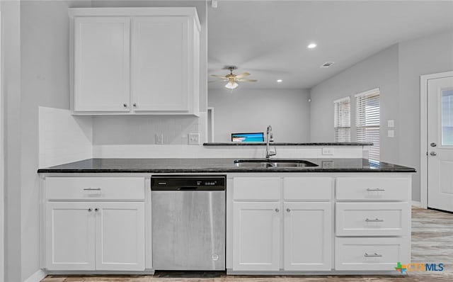 kitchen featuring tasteful backsplash, dishwasher, dark stone countertops, sink, and white cabinets