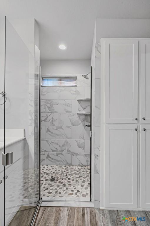 bathroom featuring hardwood / wood-style flooring and a shower with door