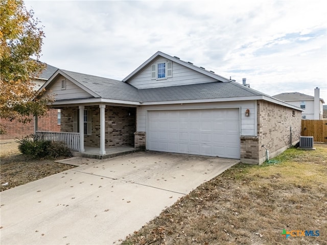 view of front of property with a garage, covered porch, and central AC