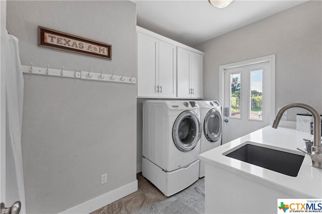 laundry room with washer and clothes dryer, cabinets, and sink