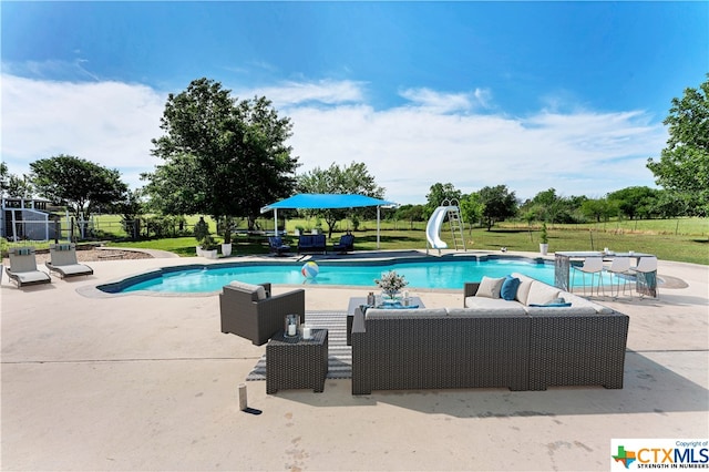 view of swimming pool with an outdoor living space, a water slide, a yard, and a patio area