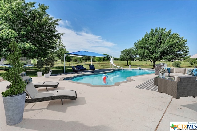 view of pool featuring a water slide, a lawn, and a patio