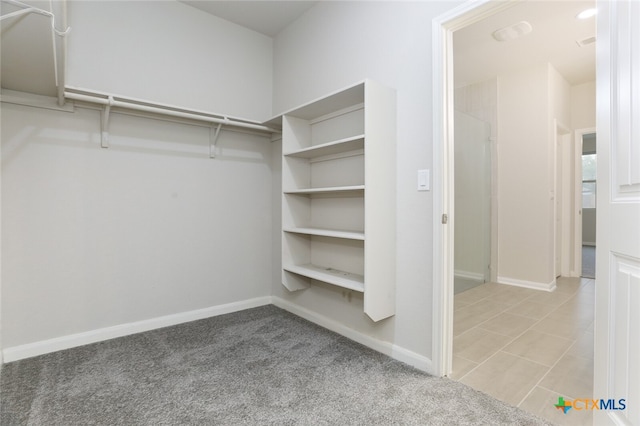 walk in closet featuring light carpet