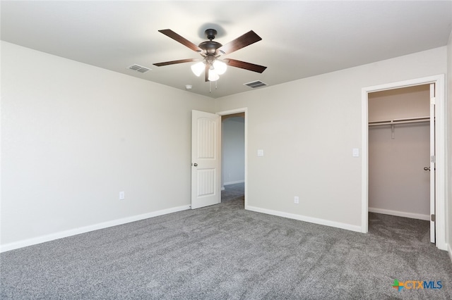 unfurnished bedroom featuring carpet, ceiling fan, a walk in closet, and a closet