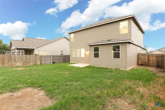 rear view of property featuring a lawn