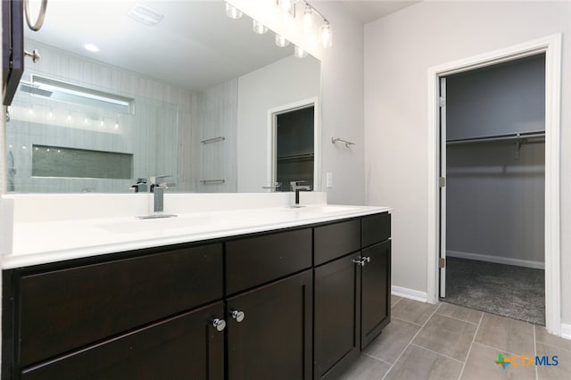 bathroom featuring tile patterned flooring, a shower, and vanity