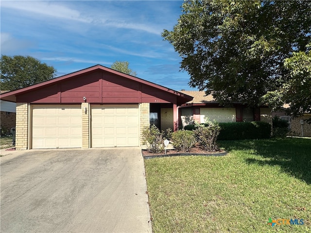 ranch-style home featuring a garage and a front lawn