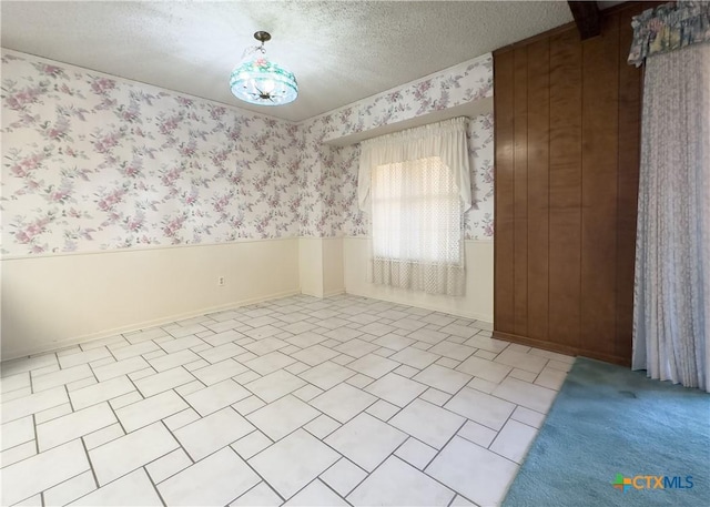 unfurnished room with a textured ceiling