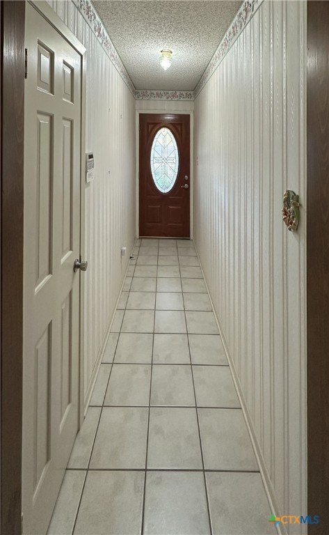 doorway featuring light tile patterned floors and a textured ceiling