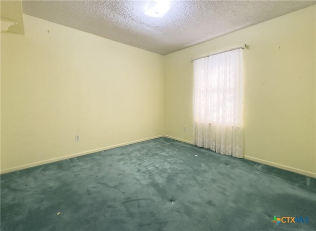 carpeted empty room featuring a textured ceiling