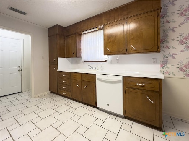 kitchen with dishwasher, a textured ceiling, and sink