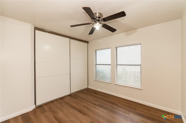 5111 Anacacho St, San Antonio, TX 78217 - unfurnished bedroom with dark wood finished floors, baseboards, a closet, and a textured ceiling