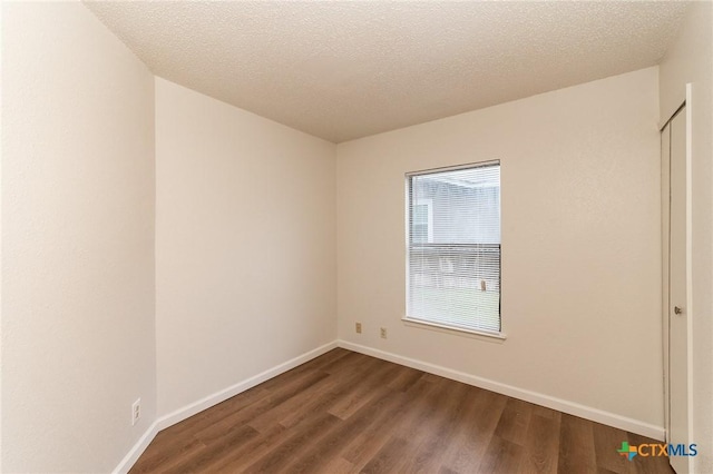 5111 Anacacho St, San Antonio, TX 78217 - spare room featuring dark wood-style floors, baseboards, and a textured ceiling