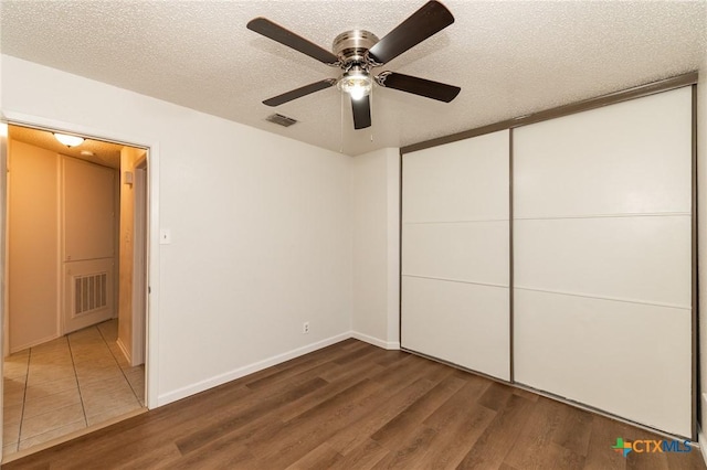 5111 Anacacho St, San Antonio, TX 78217 - unfurnished bedroom with wood finished floors, a textured ceiling, ceiling fan, a closet, and baseboards