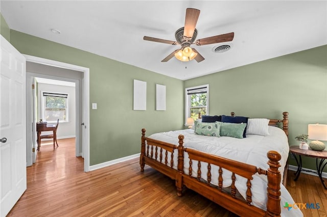 2105 S 49th St, Temple, TX 76504 - bedroom with multiple windows, baseboards, light wood-style floors, and ceiling fan