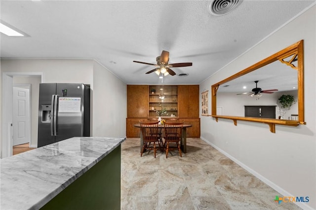 2105 S 49th St, Temple, TX 76504 - dining space with a ceiling fan, a textured ceiling, built in shelves, and baseboards