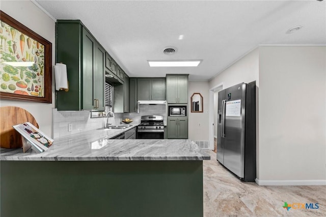 2105 S 49th St, Temple, TX 76504 - kitchen featuring stainless steel appliances, a sink, green cabinets, baseboards, and a peninsula