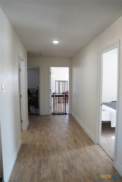 corridor with hardwood / wood-style floors