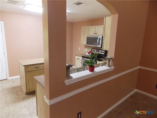 513 Pumpkin Dr, Temple, TX 76502 - kitchen featuring appliances with stainless steel finishes, arched walkways, light countertops, and light tile patterned flooring