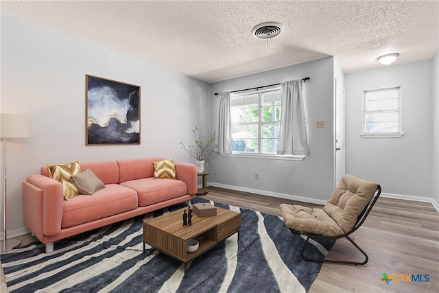 living room with hardwood / wood-style floors, a wealth of natural light, and a textured ceiling