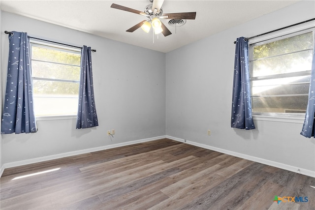 empty room with a textured ceiling, wood-type flooring, and ceiling fan