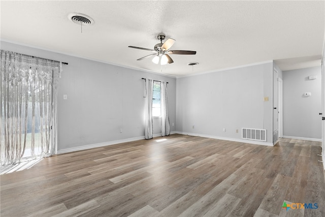 empty room featuring ornamental molding, light wood-type flooring, a textured ceiling, and ceiling fan