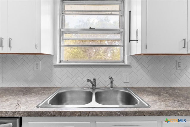 kitchen featuring white cabinets, sink, and backsplash