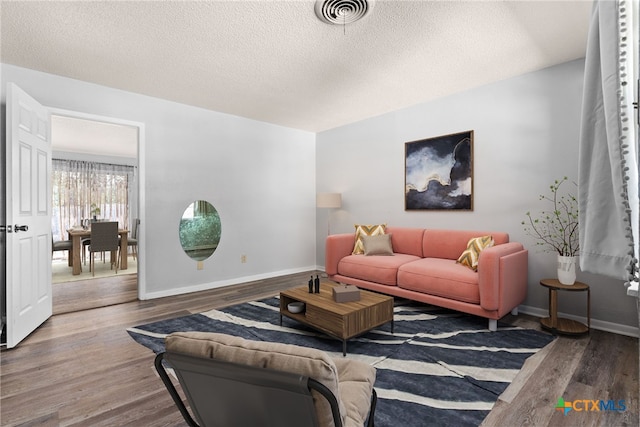 living room featuring a textured ceiling and hardwood / wood-style flooring