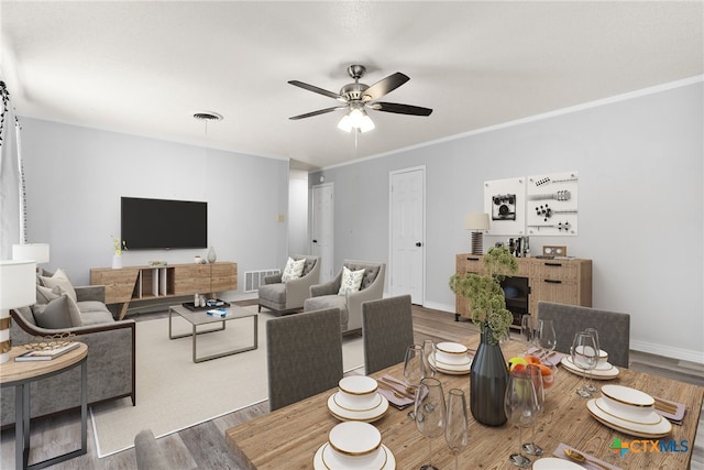 dining space with hardwood / wood-style floors, ceiling fan, and crown molding