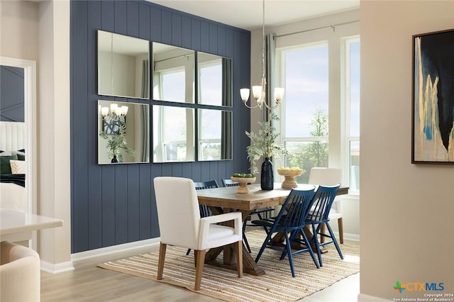 dining area with a wealth of natural light, hardwood / wood-style floors, and a notable chandelier